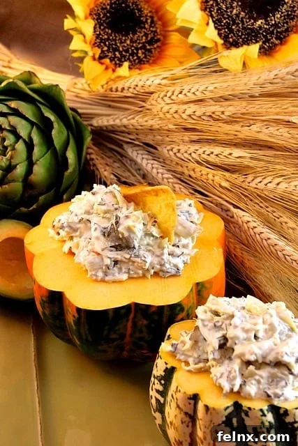 Cheesy Asiago Artichoke and Spinach Dip in a decorative autumn setting