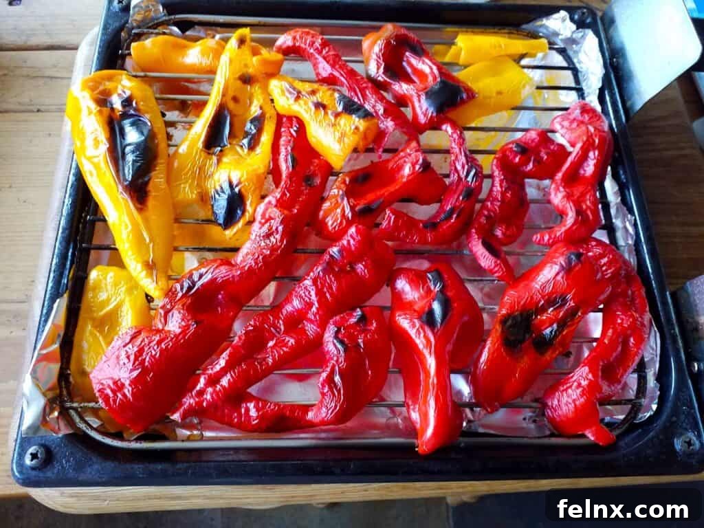 Freshly roasted and peeled red bell peppers on a wooden board