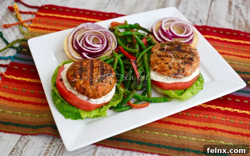Grilled salmon burgers served with roasted green beans and red peppers