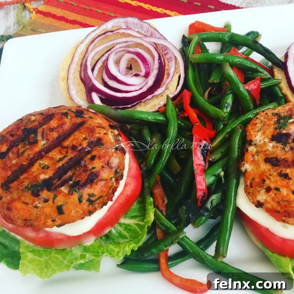 A close-up of a salmon burger with garlic lemon aioli and fresh toppings