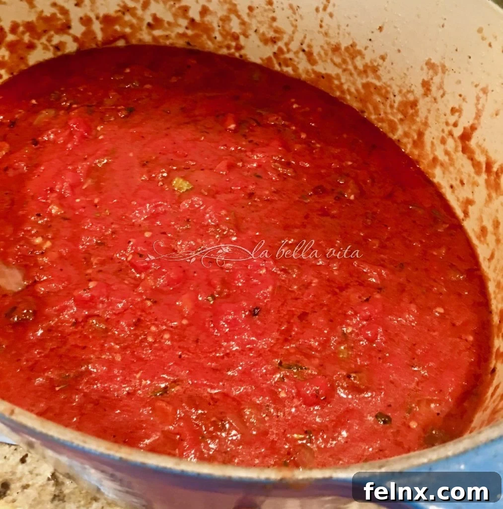 Adding tomatoes and herbs to the pot