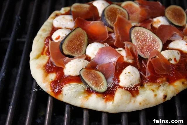 The pizza cooking on a hot grill with the cheese beginning to melt
