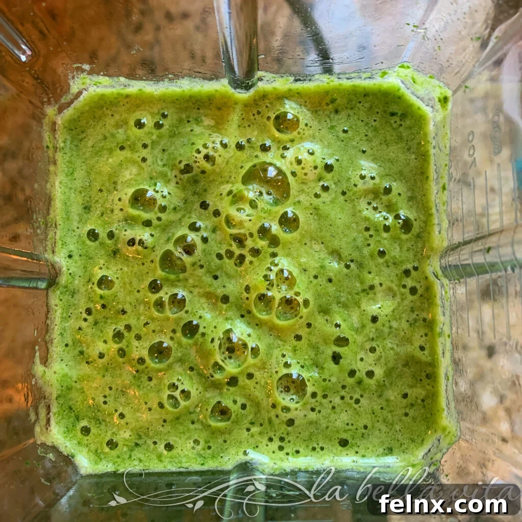 Glass of green smoothie with pineapple garnish