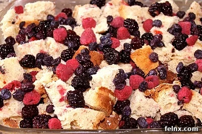 Adding berries to the bread pudding layers