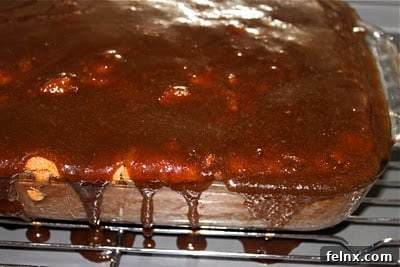 Pouring hot caramel glaze over apple cake