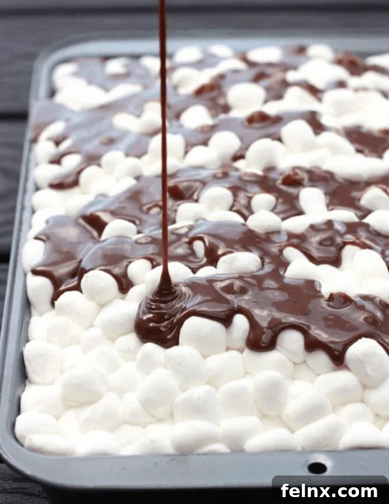 Pouring chocolate frosting over marshmallows