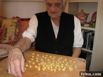 Organized rows of finished tortellini on a wooden board