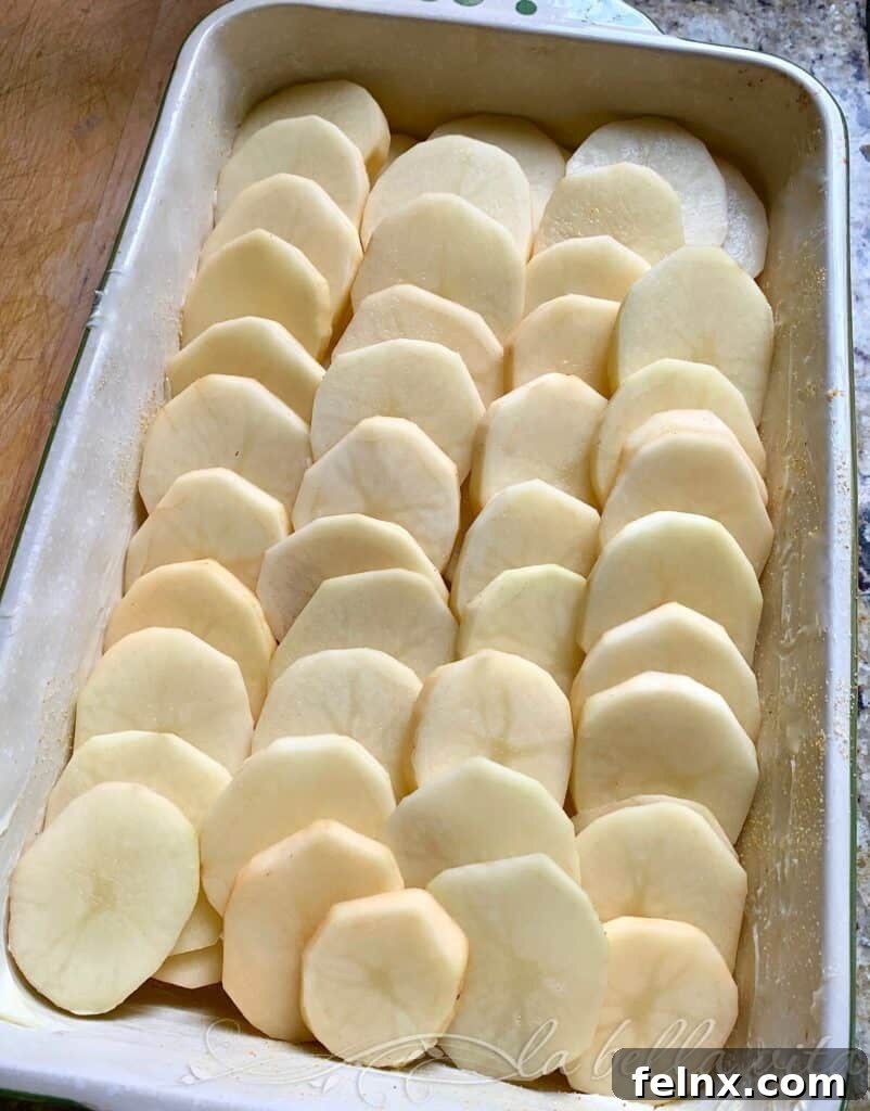 Layering potatoes in a buttered dish
