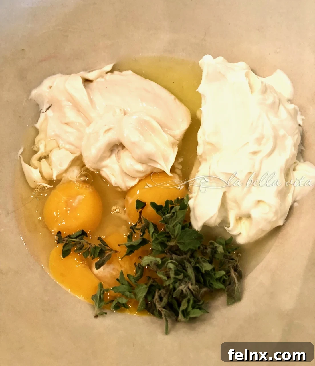 Whisking eggs, ricotta, and herbs in a bowl