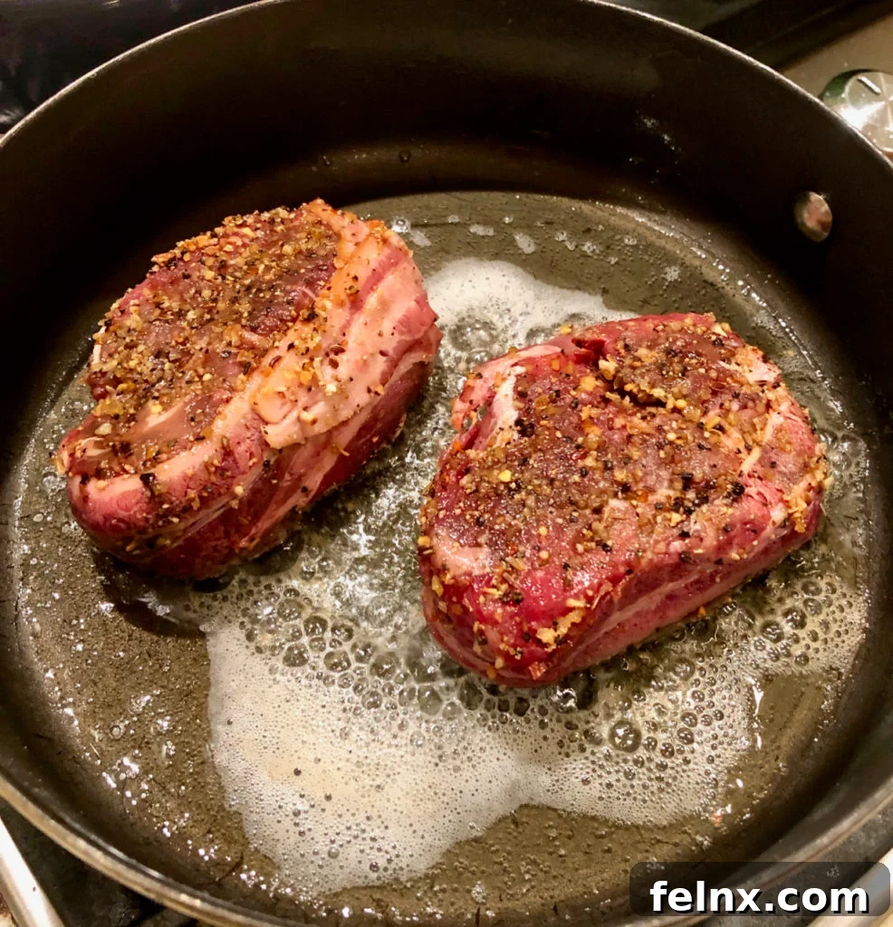 Steaks searing in a cast iron pan