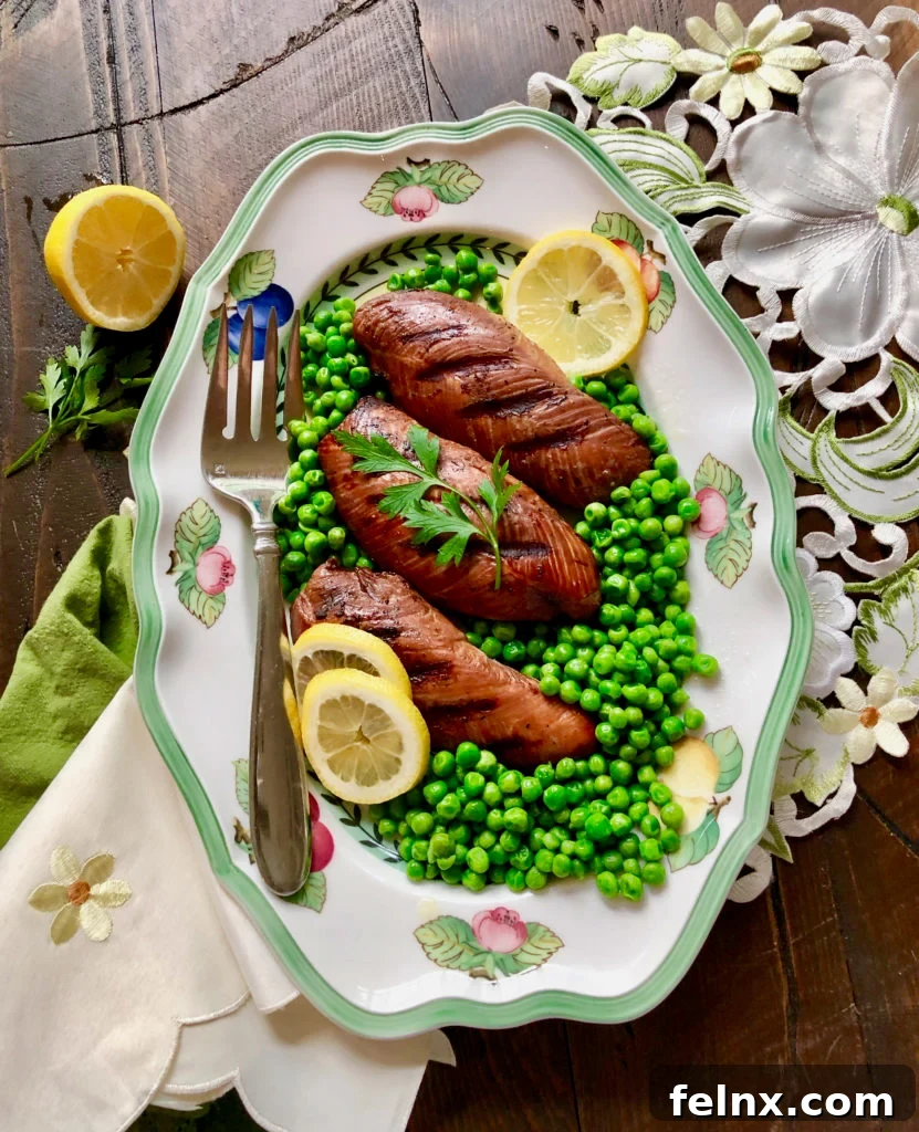 Plated grilled turkey breasts with fresh herbs and lemon slices.