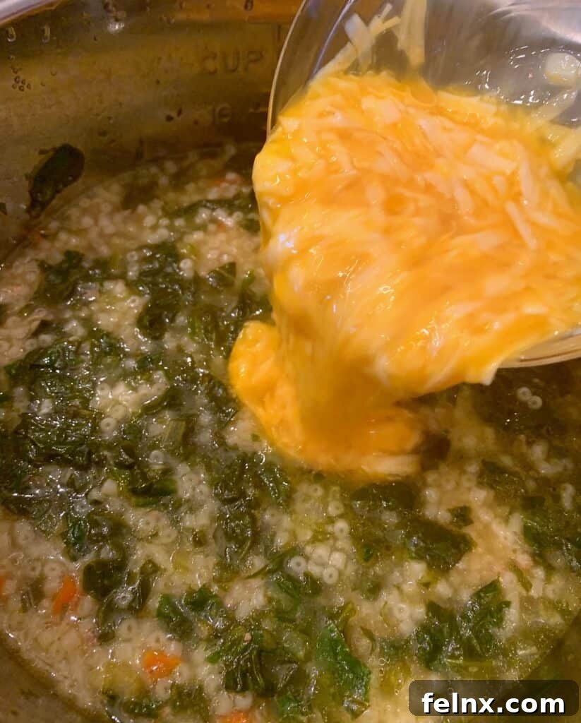 Drizzling egg and cheese mixture into the soup