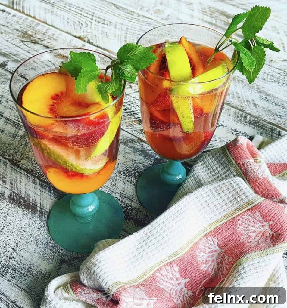 Southern Peach Sangria in a glass pitcher with fresh peach slices