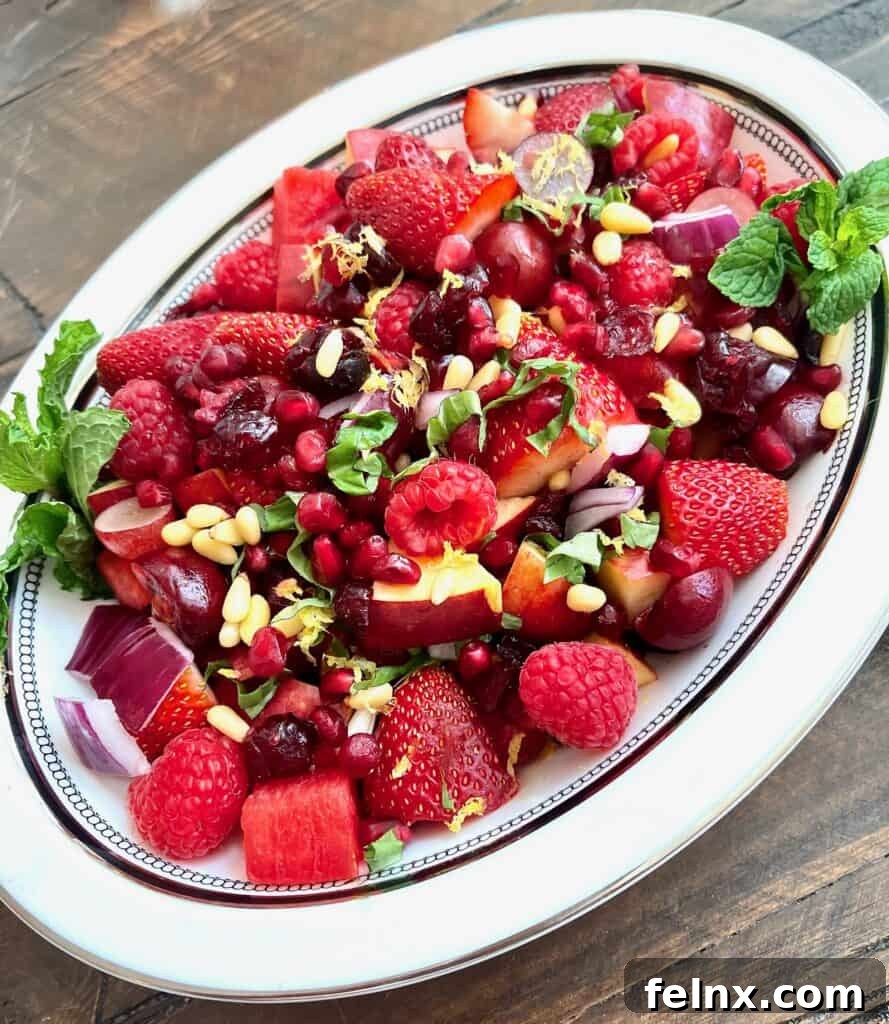 Top view of the red fruit salad showing pomegranate seeds and sliced strawberries