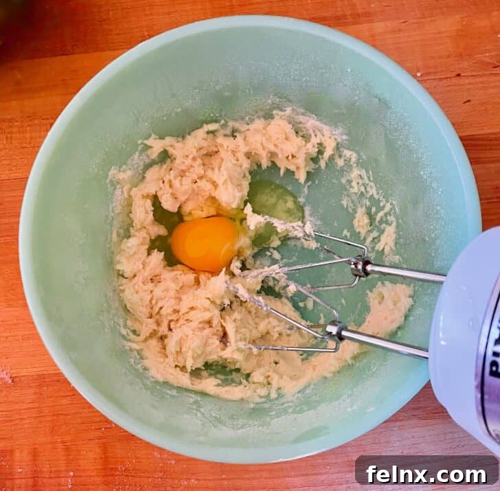 Adding eggs to the cookie batter