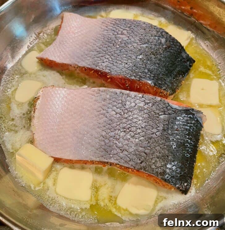 Searing salmon in a pan with olive oil
