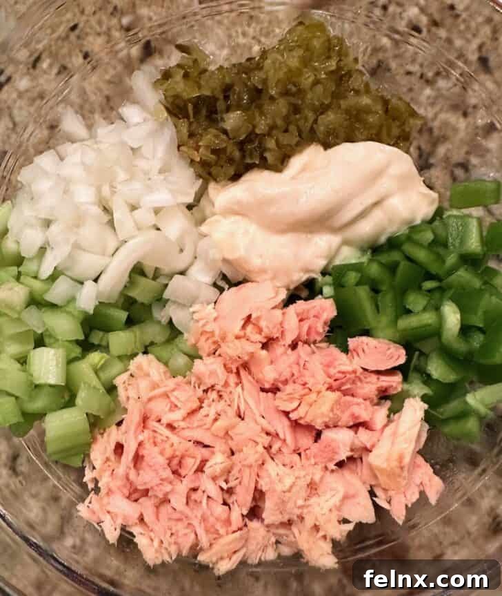 Ingredients for tuna salad including celery, onions, and tuna cans
