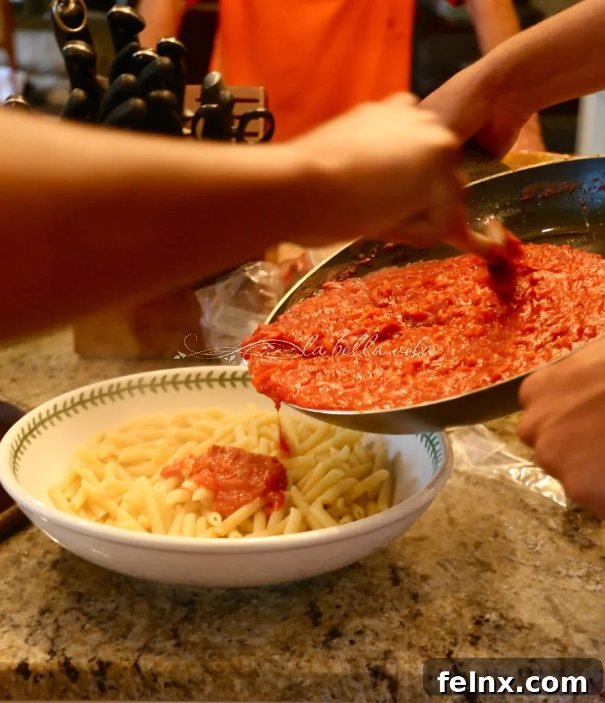 Combining the pasta with the rich Amatriciana sauce