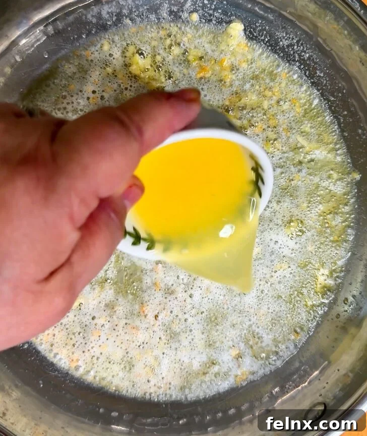 Fresh lemon juice and zest being added to the butter mixture.
